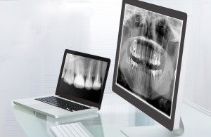 Doctor or radiologist looking at an x-ray online displayed on a desktop monitor as he makes a diagnosis or checks prognosis